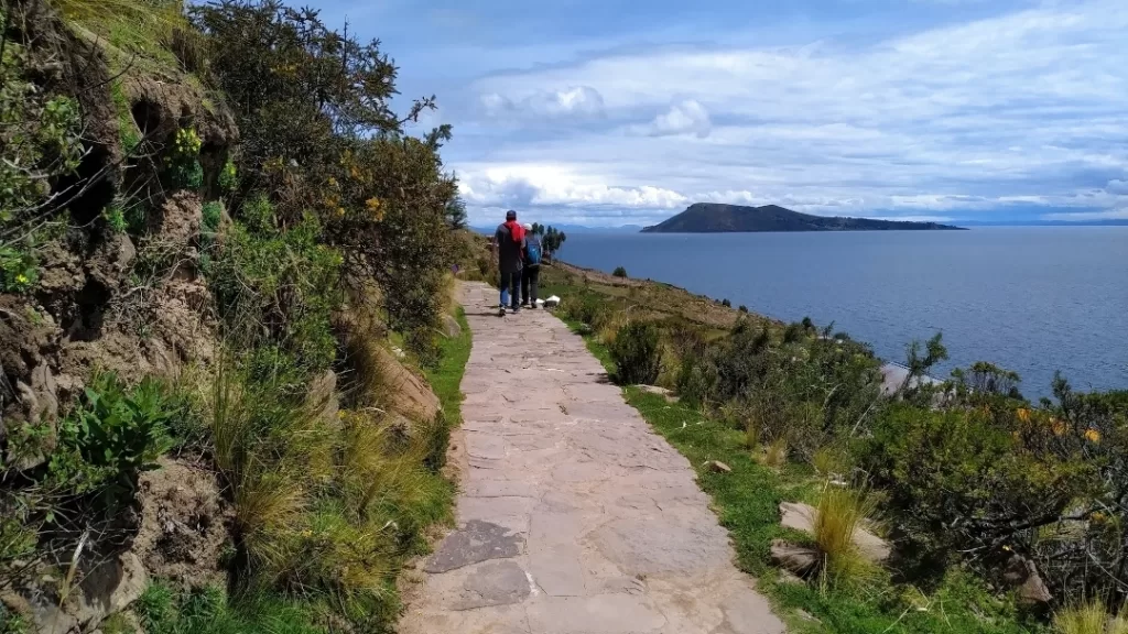 Hiking the stone path in Taquile with Amantani in the distance