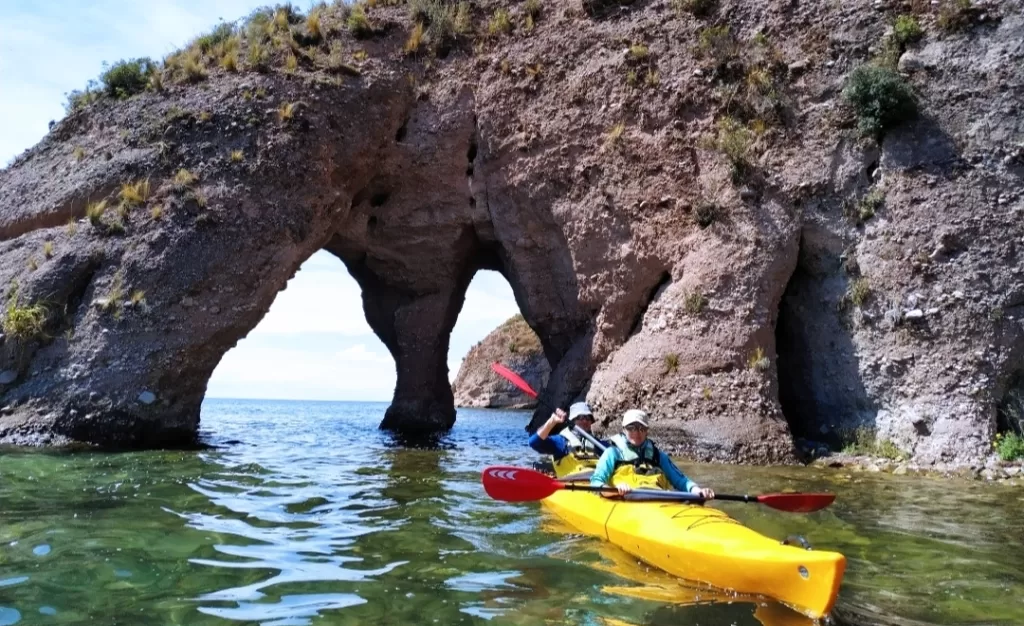 Paddling under the stone arch in Luquina