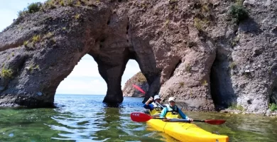 Paddling under the stone arch in Luquina